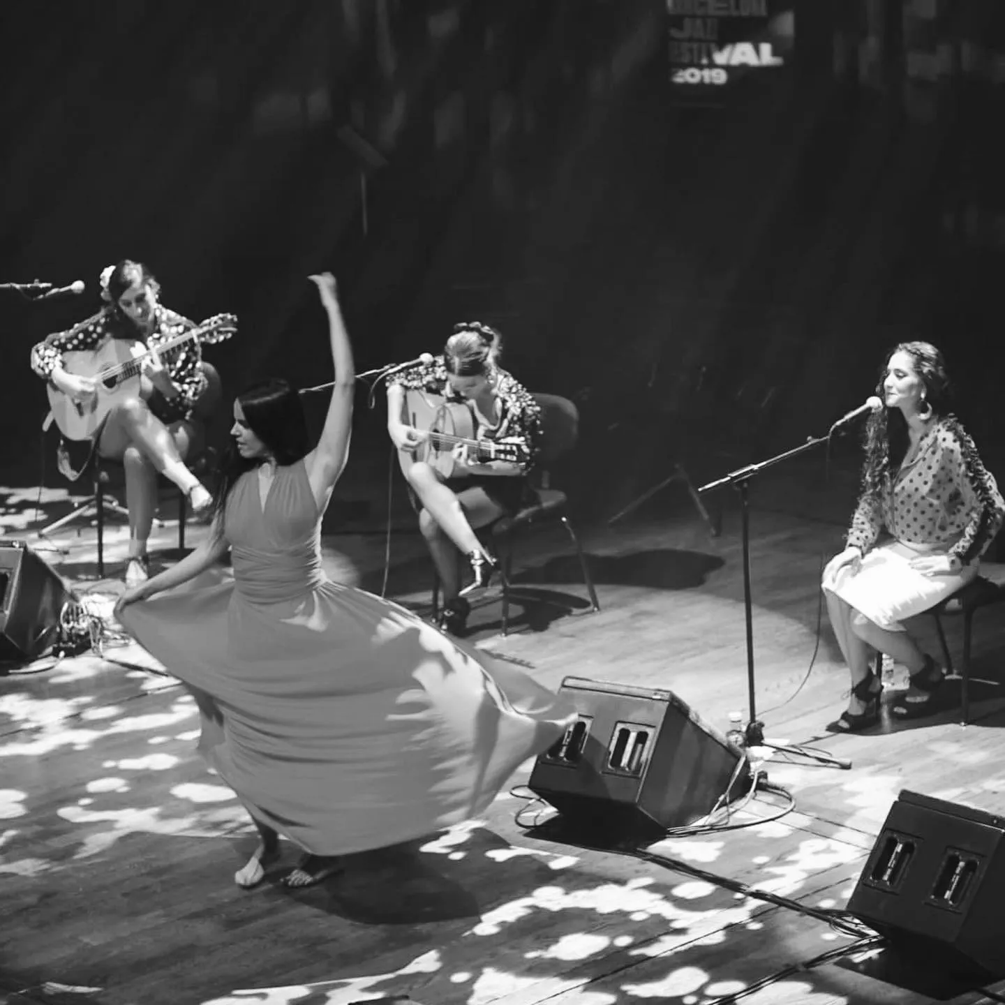 Aina Núñez hace girar la falda en el escenario, con dos guitarras y una cantante detrás.