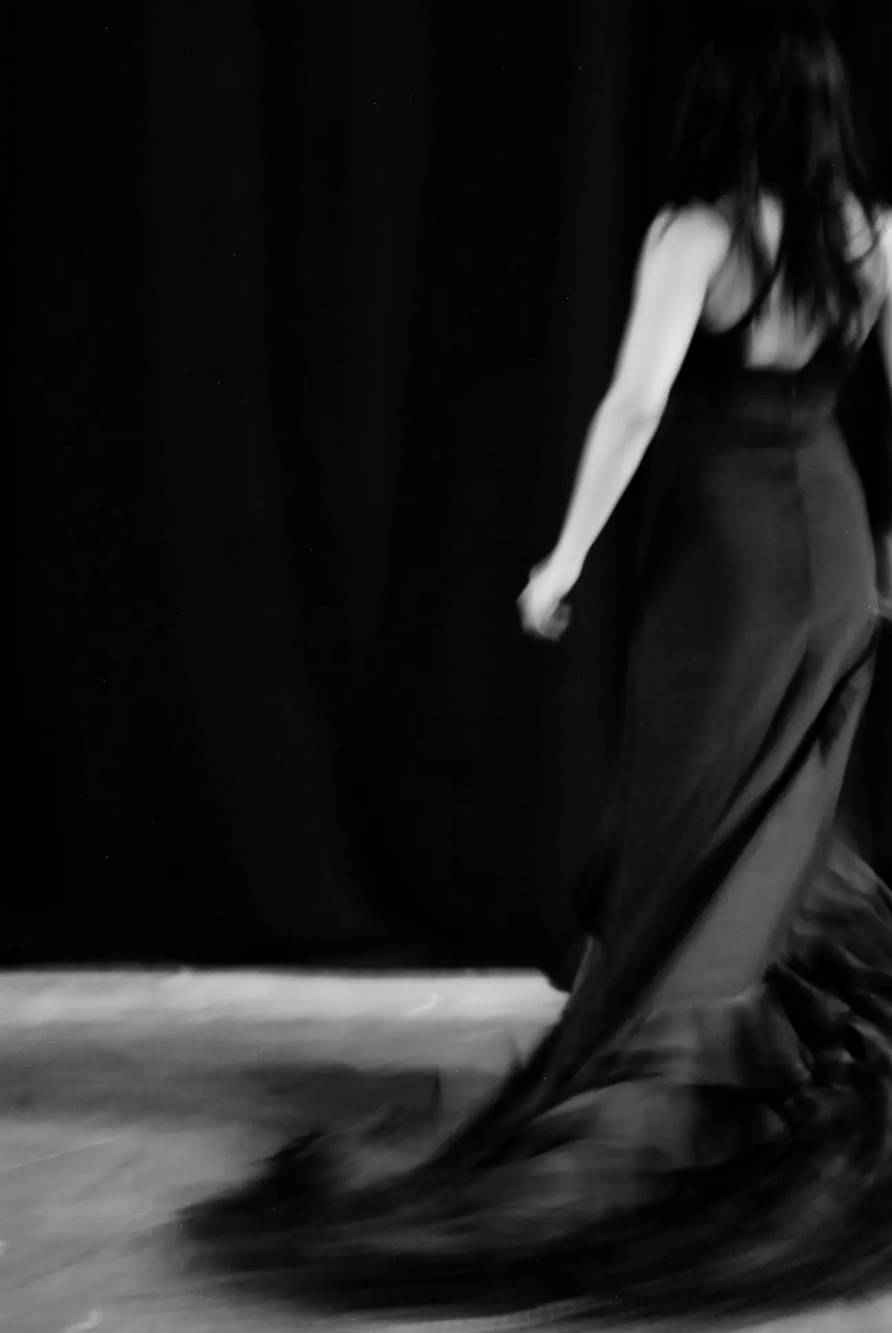 Aina Núñez camina de espaldas arrastrando la cola del vestido, que barre el suelo.
