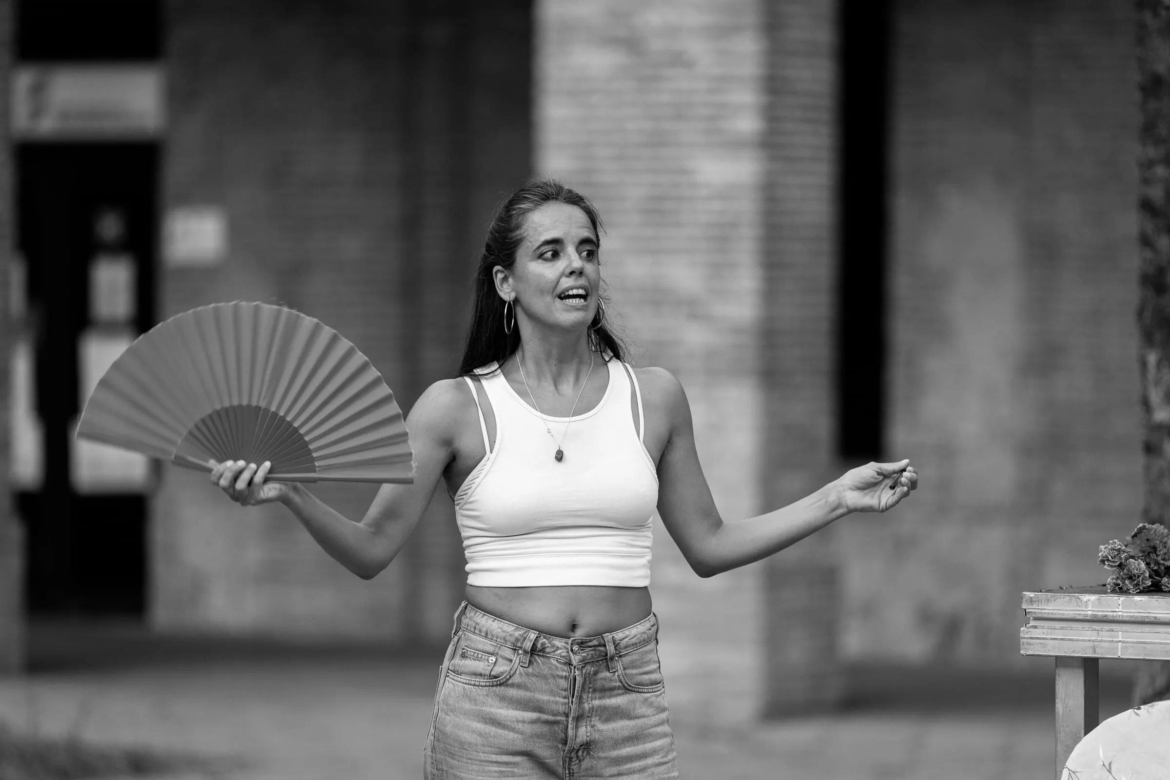 Aina Núñez, al aire libre y con un abanico abierto en la mano, se dirige al público.
