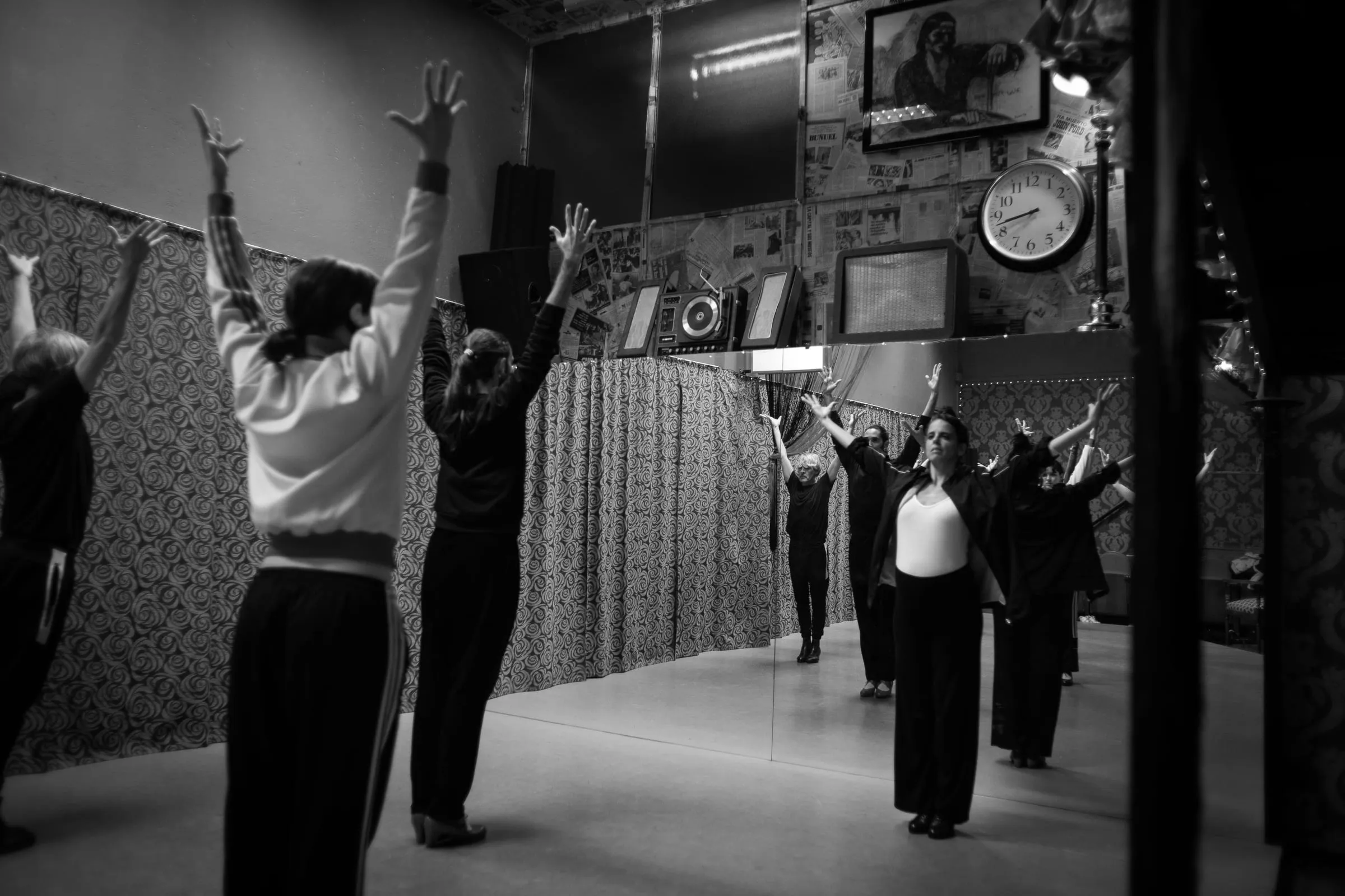Clase de flamenco en el estudio: varias alumnas levantan los brazos frente al espejo de la sala.